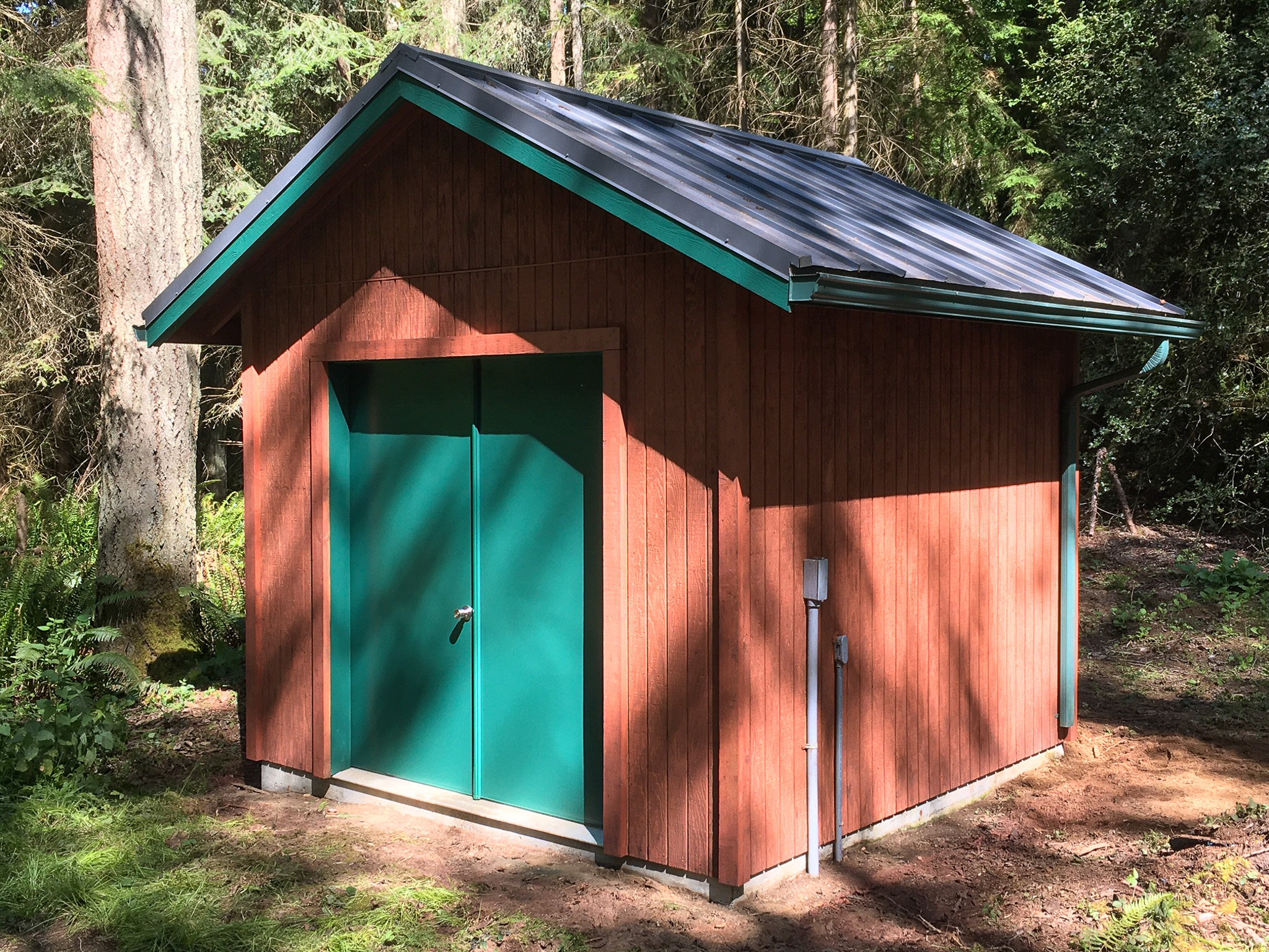 Small pump house, beautiful stained wood with green trim.